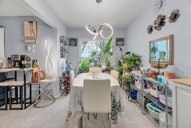 dining area with a chandelier and light colored carpet