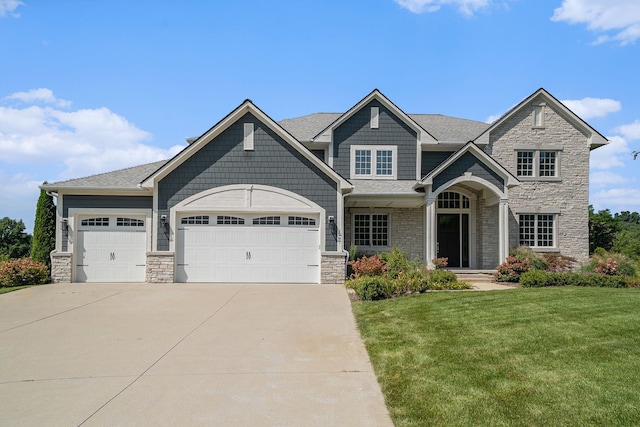 craftsman house with a front lawn and a garage