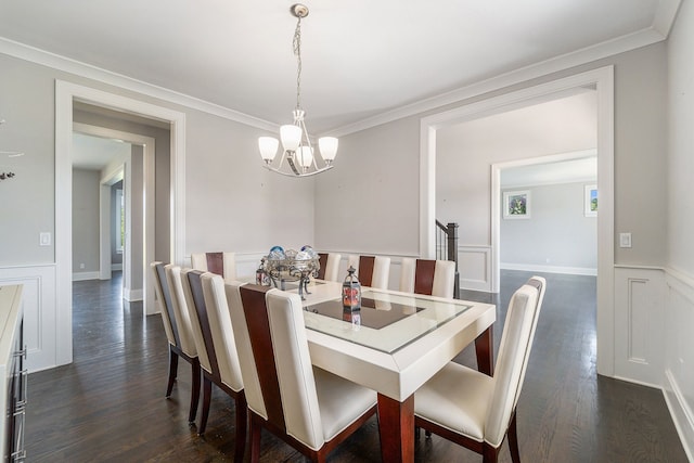 dining room featuring dark hardwood / wood-style flooring, an inviting chandelier, and ornamental molding