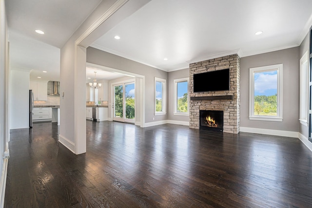 unfurnished living room featuring a stone fireplace, a chandelier, dark wood-type flooring, and ornamental molding