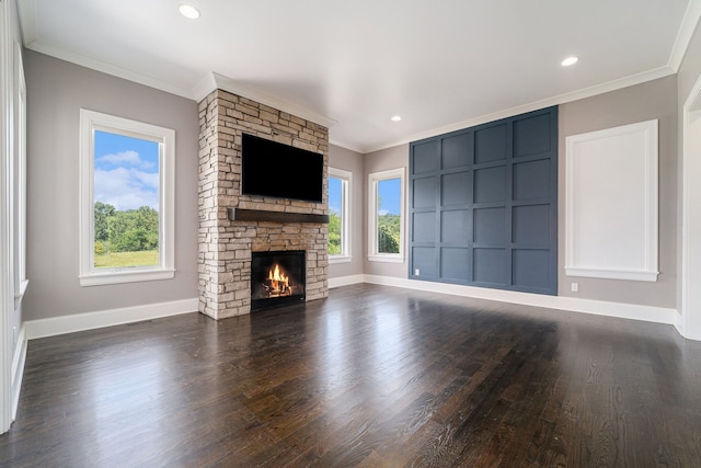 unfurnished living room featuring dark hardwood / wood-style flooring, a stone fireplace, and ornamental molding