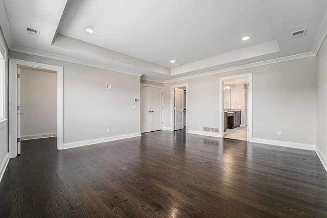 spare room with dark hardwood / wood-style floors, a raised ceiling, and ornamental molding