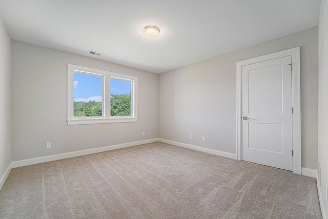 spare room featuring light colored carpet