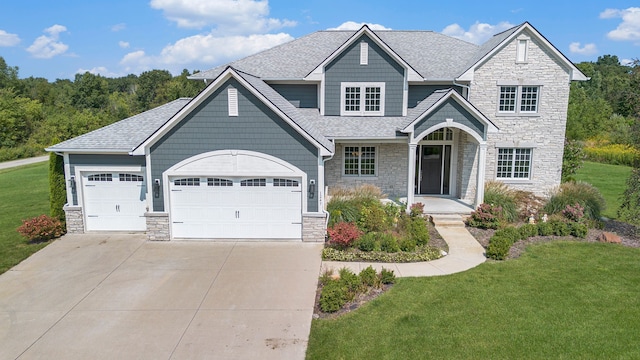 craftsman house featuring a front yard and a garage