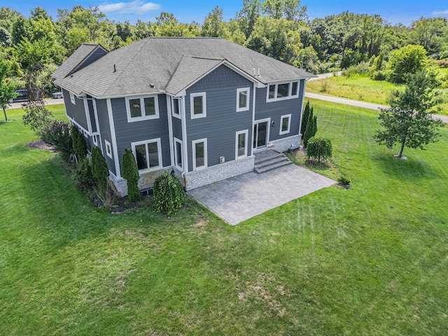 back of property with a yard and a patio