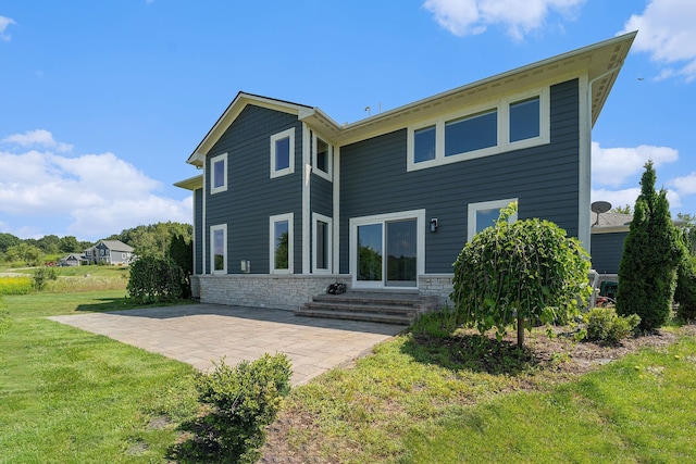 back of property with a yard and a patio area