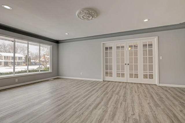 spare room with light hardwood / wood-style floors, crown molding, and french doors