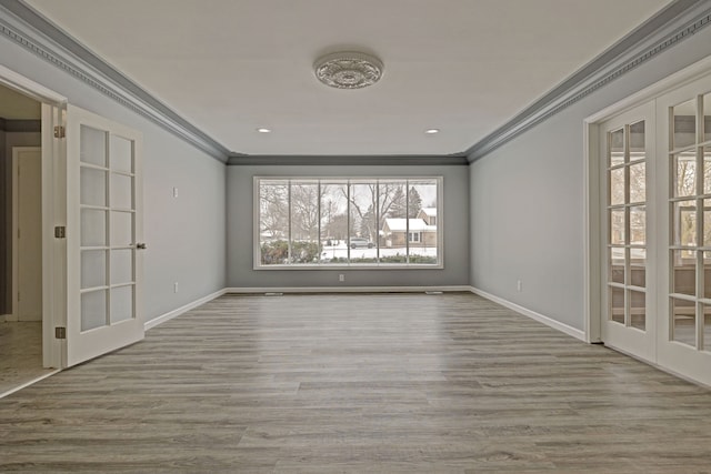 empty room featuring ornamental molding, light hardwood / wood-style flooring, and french doors