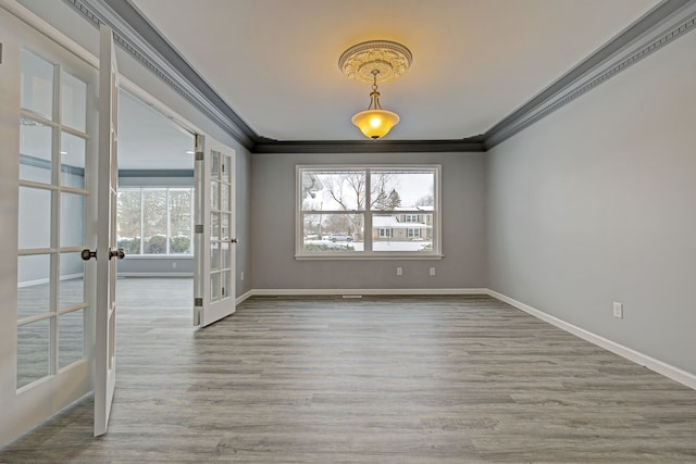 empty room featuring hardwood / wood-style flooring, ornamental molding, and french doors