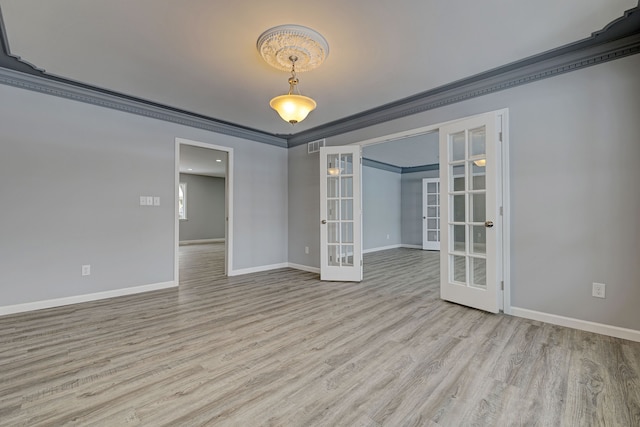 empty room featuring light hardwood / wood-style floors, crown molding, and french doors