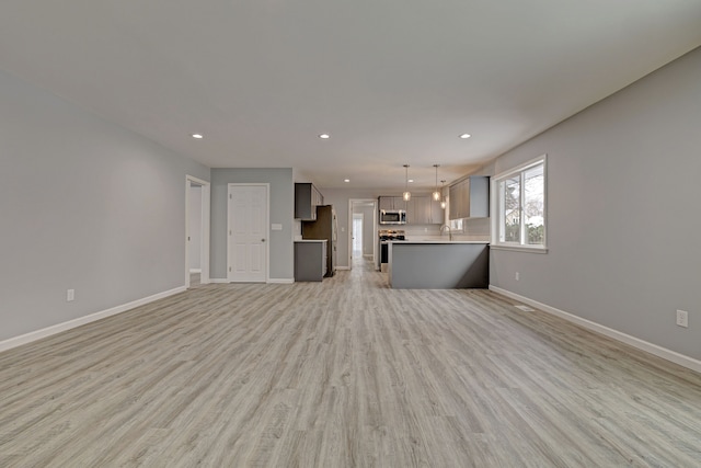 unfurnished living room featuring light hardwood / wood-style flooring and sink