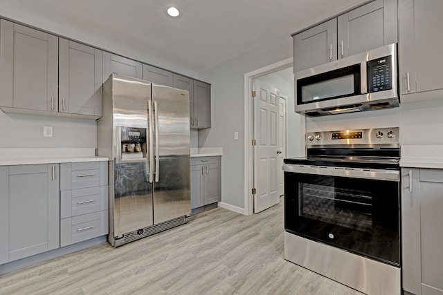 kitchen featuring gray cabinets, light hardwood / wood-style floors, and stainless steel appliances