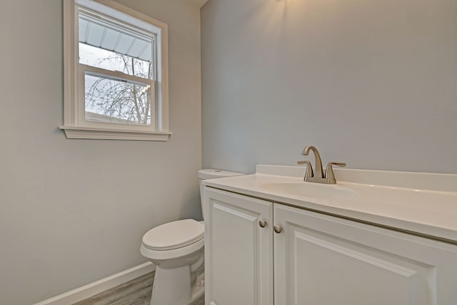 bathroom with hardwood / wood-style floors, vanity, and toilet