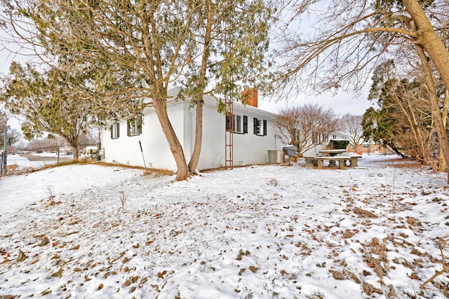 view of snow covered back of property