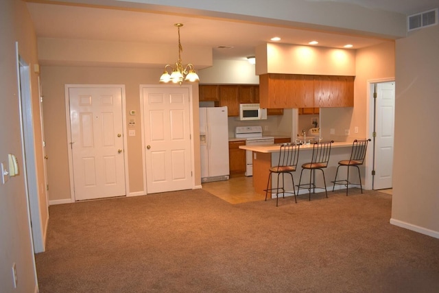 kitchen featuring carpet flooring, an inviting chandelier, decorative light fixtures, white appliances, and a breakfast bar