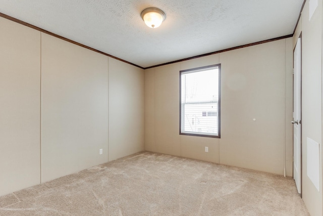unfurnished room featuring a textured ceiling, carpet flooring, and crown molding