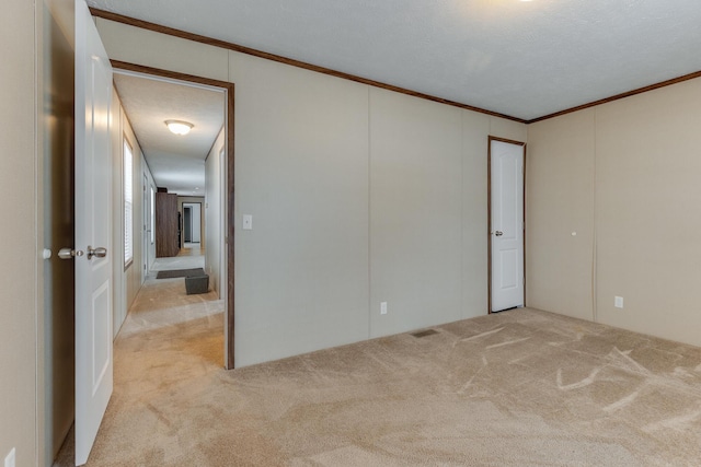 empty room with crown molding and carpet flooring