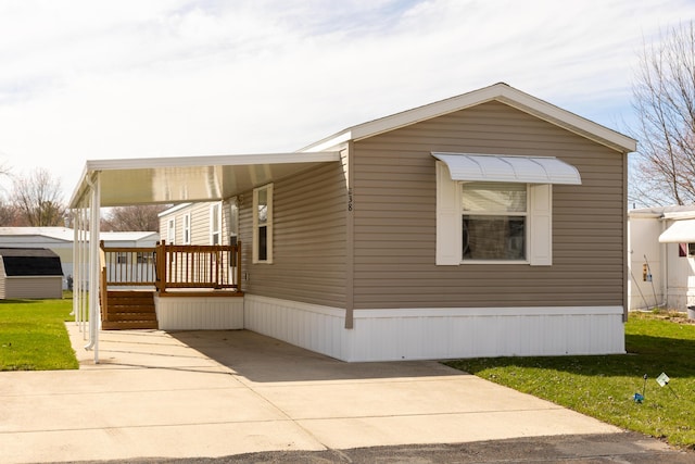 view of front of house with an attached carport, a wooden deck, and a front lawn