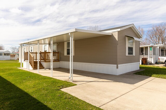 view of home's exterior with an attached carport and a lawn