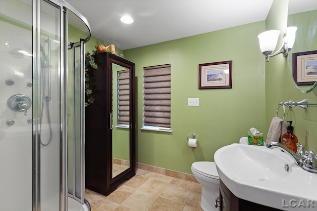 bathroom with toilet, a shower with shower door, and sink