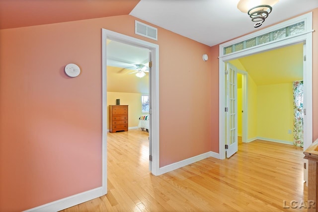 hall featuring hardwood / wood-style flooring and lofted ceiling