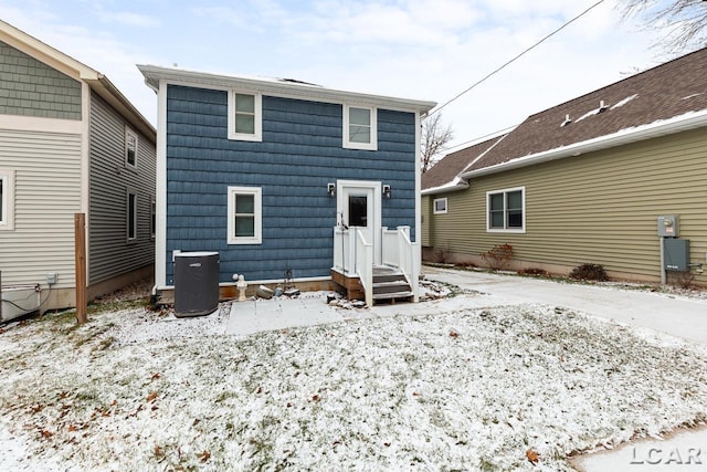 snow covered rear of property with central air condition unit