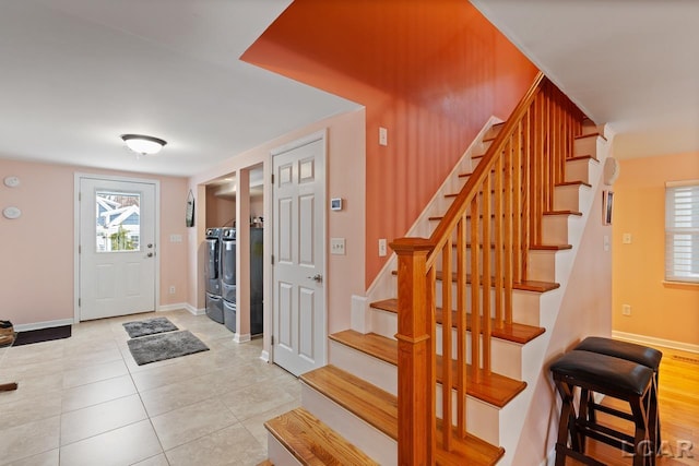 tiled foyer featuring washer and dryer