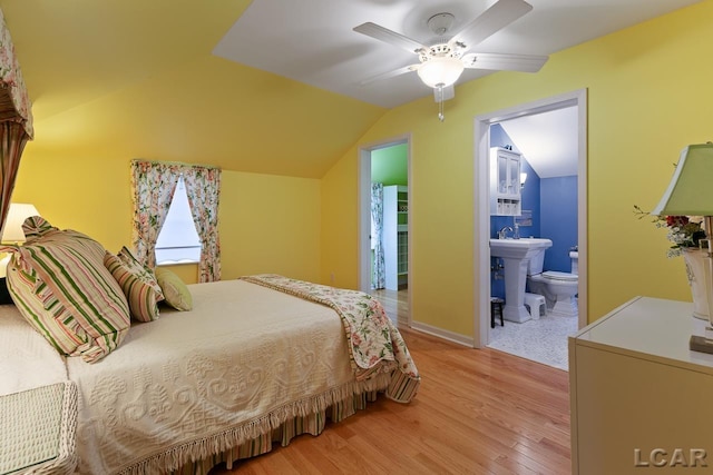 bedroom featuring ensuite bath, ceiling fan, light hardwood / wood-style flooring, and lofted ceiling