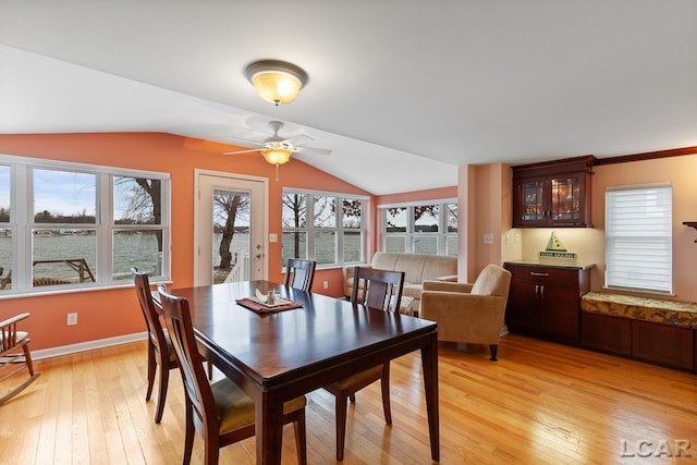 dining space featuring ceiling fan, light hardwood / wood-style floors, and vaulted ceiling