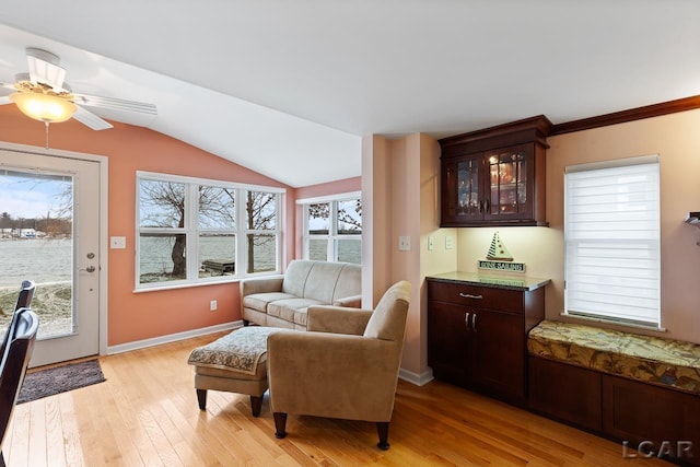 sitting room with ceiling fan, light hardwood / wood-style floors, crown molding, and vaulted ceiling