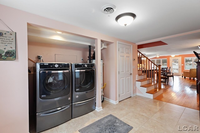 clothes washing area featuring independent washer and dryer and light tile patterned floors