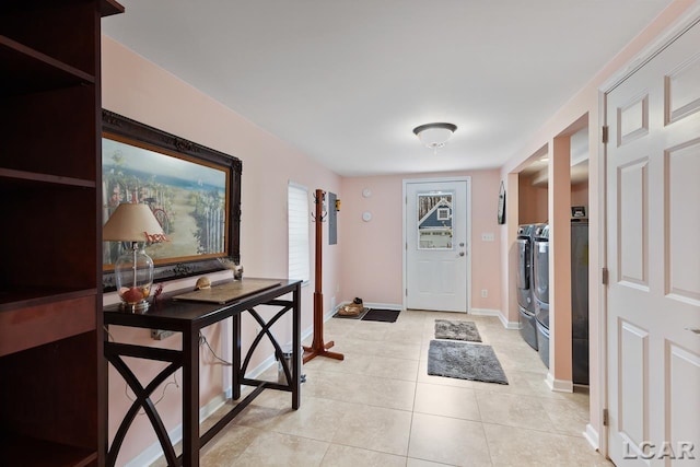 tiled entryway with washer and clothes dryer