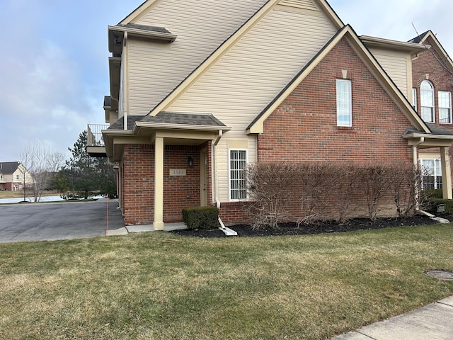 view of front facade featuring a front yard and a balcony