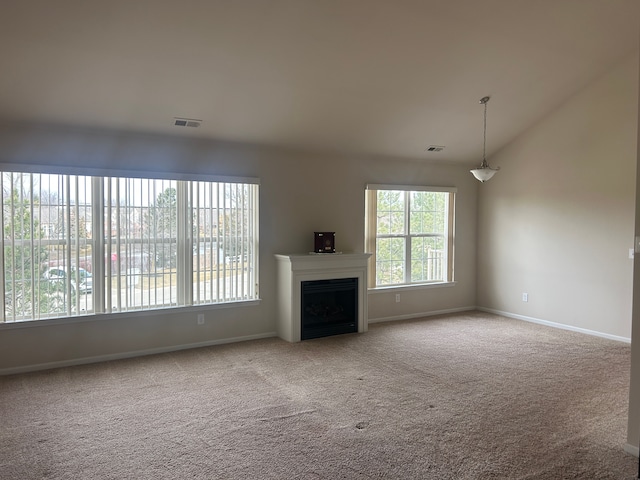 unfurnished living room with carpet floors, a fireplace, visible vents, and vaulted ceiling