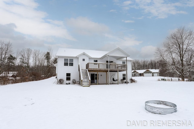 snow covered house featuring a wooden deck