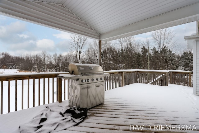 snow covered deck with a grill