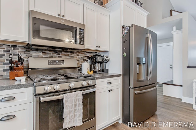 kitchen featuring backsplash, appliances with stainless steel finishes, light hardwood / wood-style floors, and white cabinets