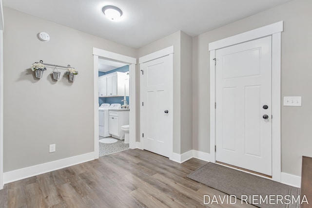 entryway featuring washing machine and clothes dryer and light hardwood / wood-style floors