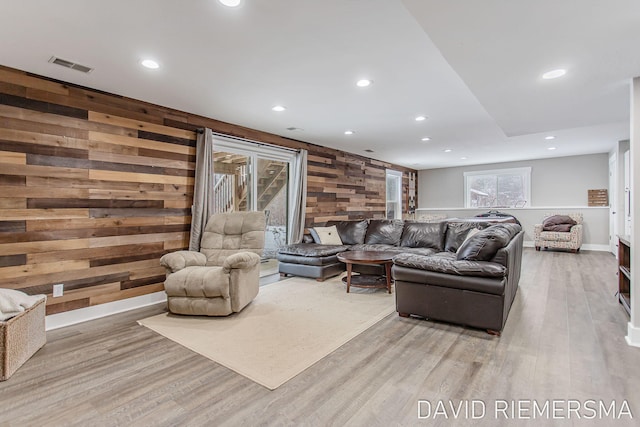 living room with hardwood / wood-style flooring and wood walls