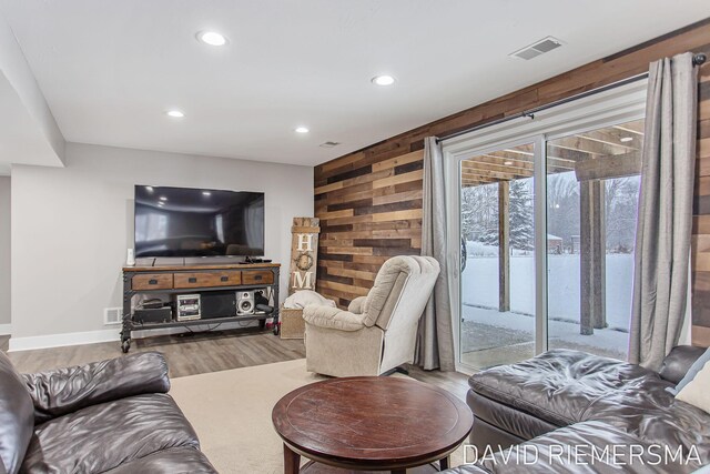 living room with wooden walls and light wood-type flooring