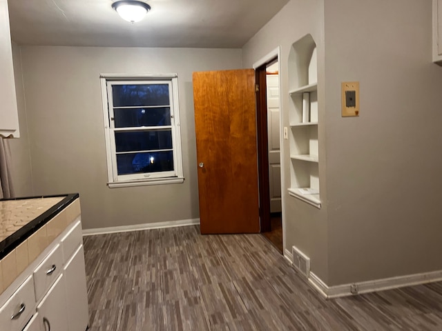 interior space featuring white cabinetry and dark wood-type flooring