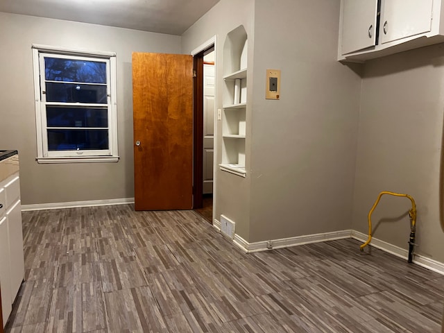 laundry room with dark wood-type flooring and cabinets