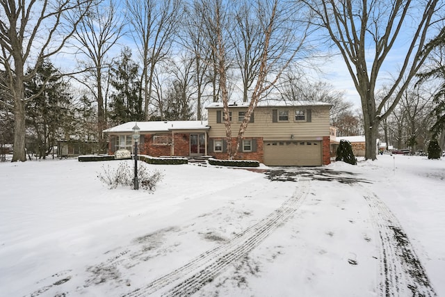 snow covered back of property with a garage