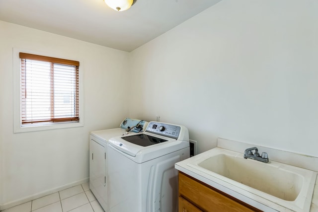 clothes washing area featuring washer and clothes dryer, light tile patterned floors, and sink