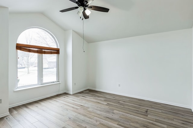 spare room featuring a healthy amount of sunlight, ceiling fan, light hardwood / wood-style floors, and lofted ceiling