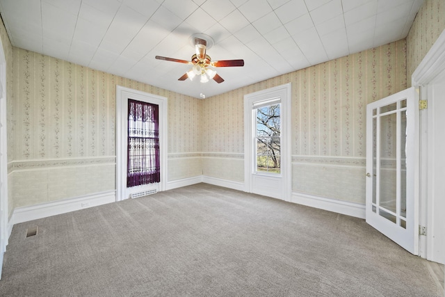 unfurnished room featuring ceiling fan, carpet, and a healthy amount of sunlight