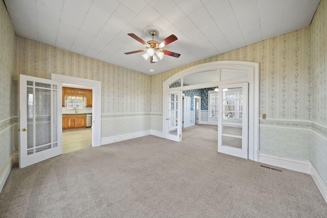 empty room with light carpet, french doors, ceiling fan, and sink