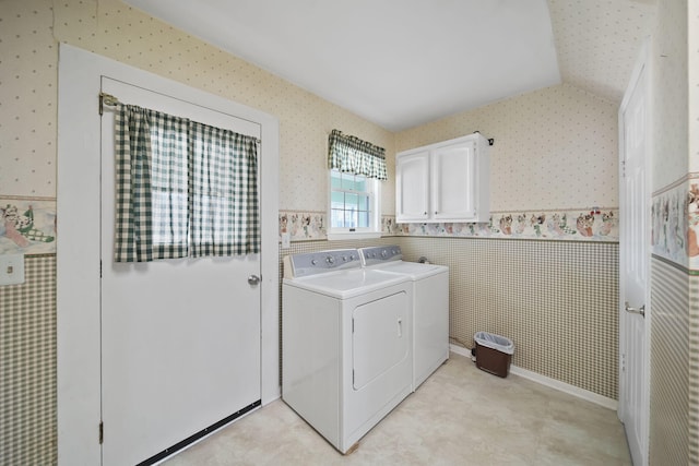 clothes washing area featuring washer and dryer and cabinets