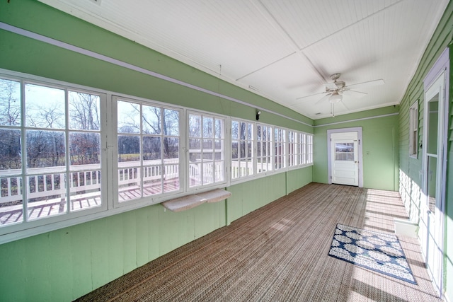 unfurnished sunroom with ceiling fan