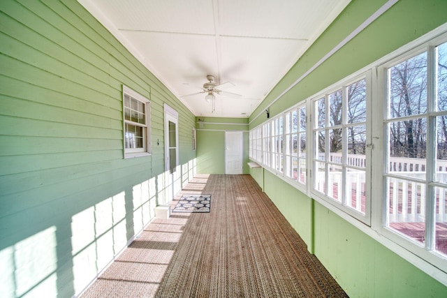 unfurnished sunroom with ceiling fan and lofted ceiling